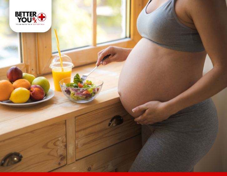 pregnant woman wearing exercise clothes eating vegatables and fruits